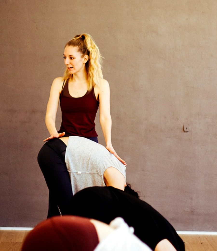 Leda Fay guiding a student during a yoga class